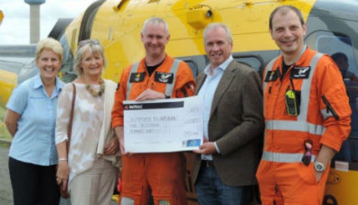 Technician hands over charity cheque after being pinned under car