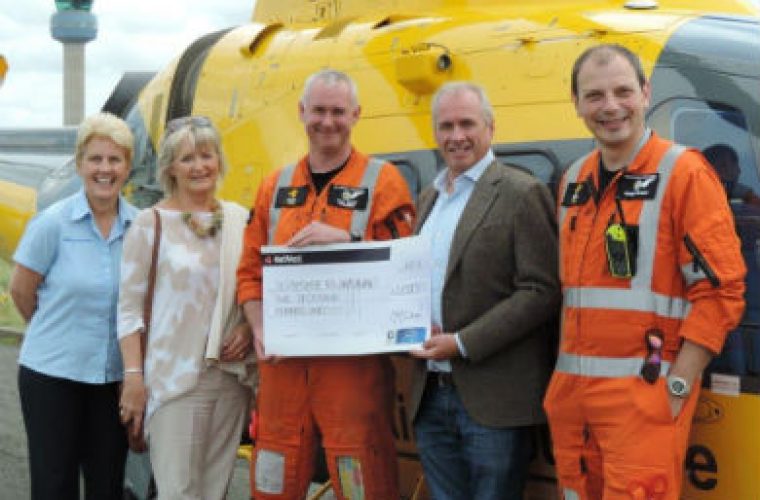 Technician hands over charity cheque after being pinned under car