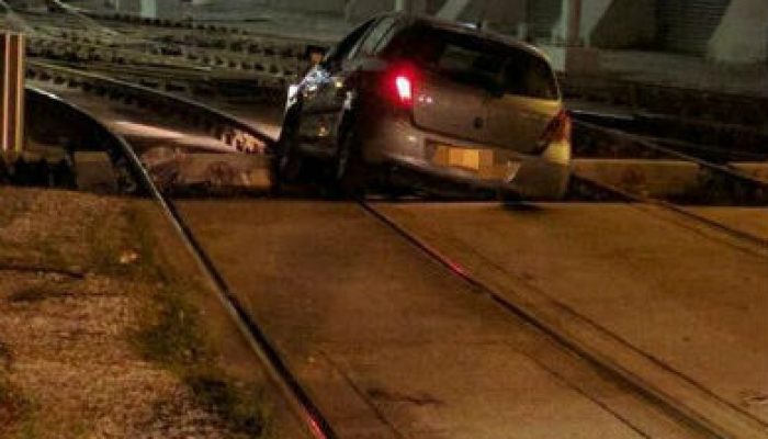Oblivious motorist drives on tram tracks and gets stuck at station