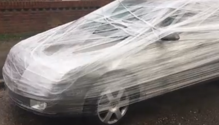 Video: frustrated man cling-films car parked outside his house