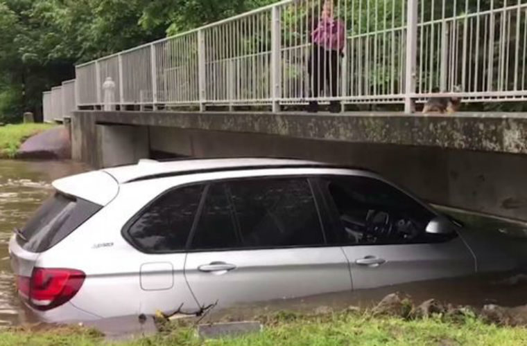 Video: £60k BMW X5 swept away by flood and left wedged under bridge